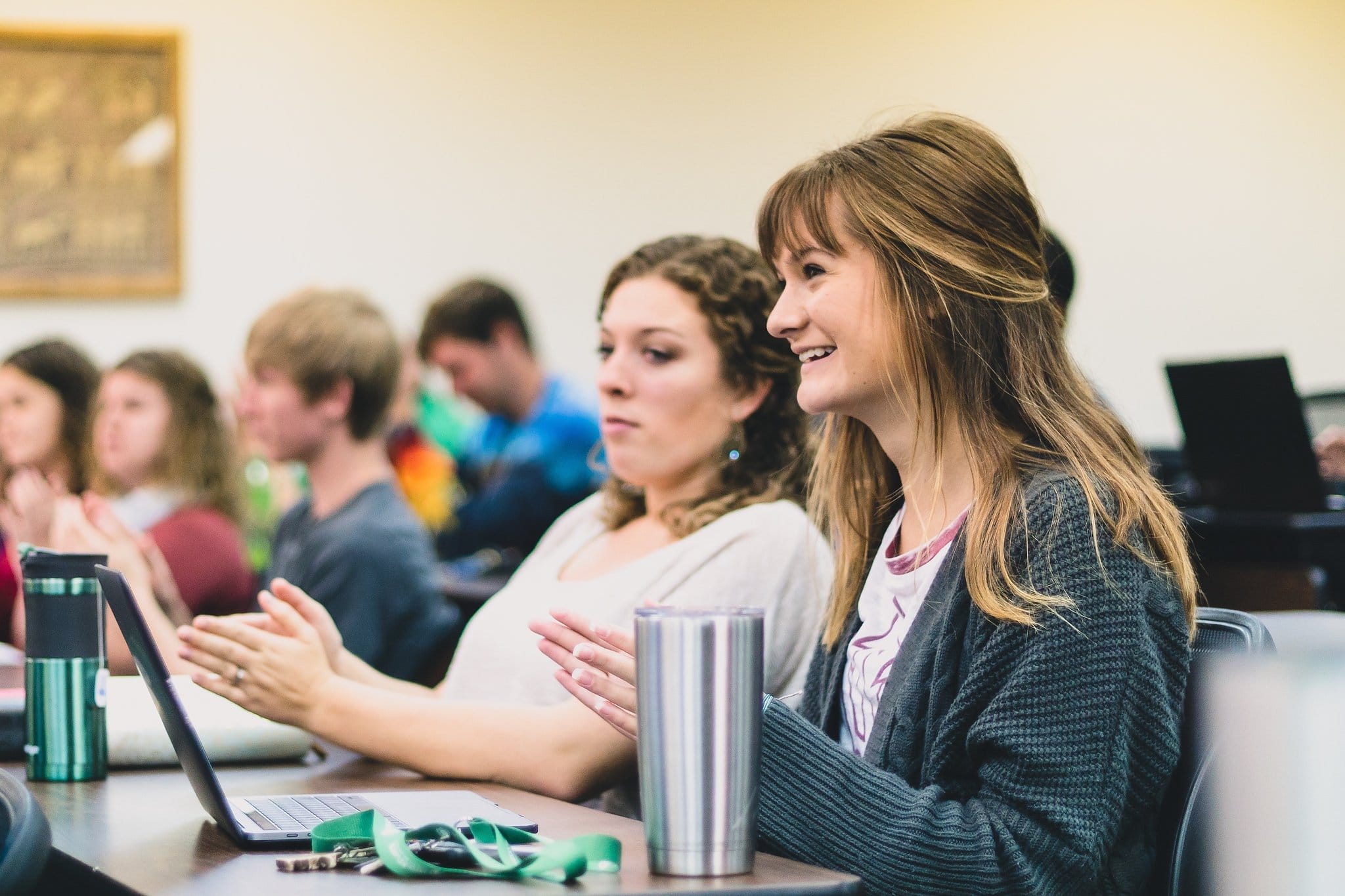 Female student earning a business administration degree sitting in a classroom listening to a college lecture.