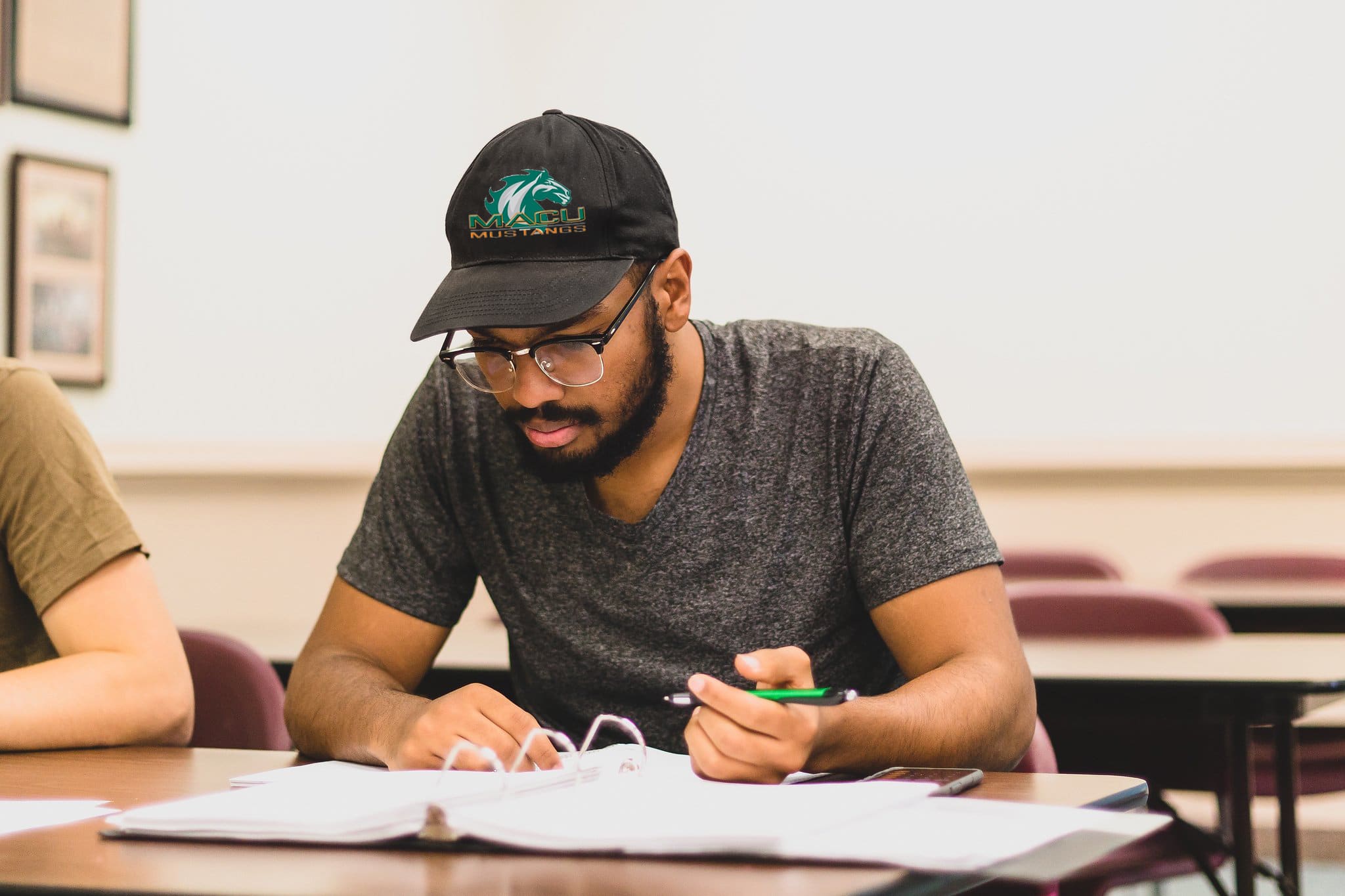 College student sitting at desk considering choosing a major.