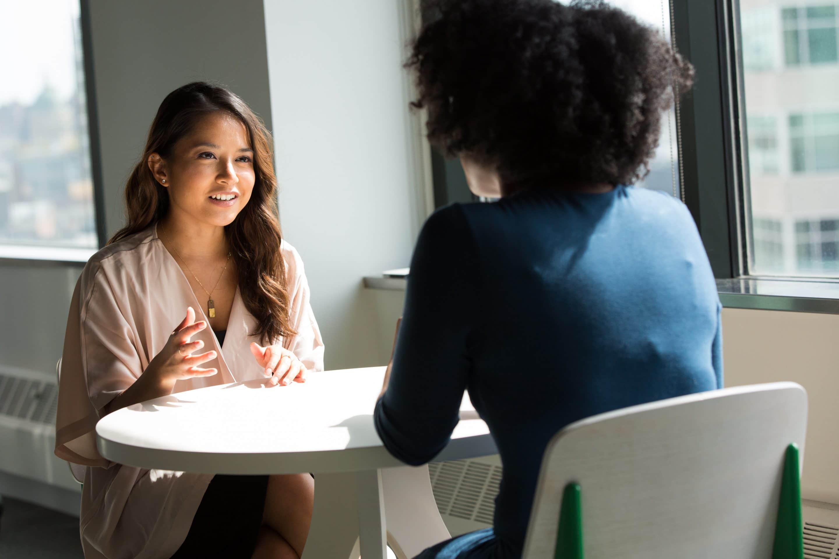 Two psychology degree students sitting at a table and discussing their career options.