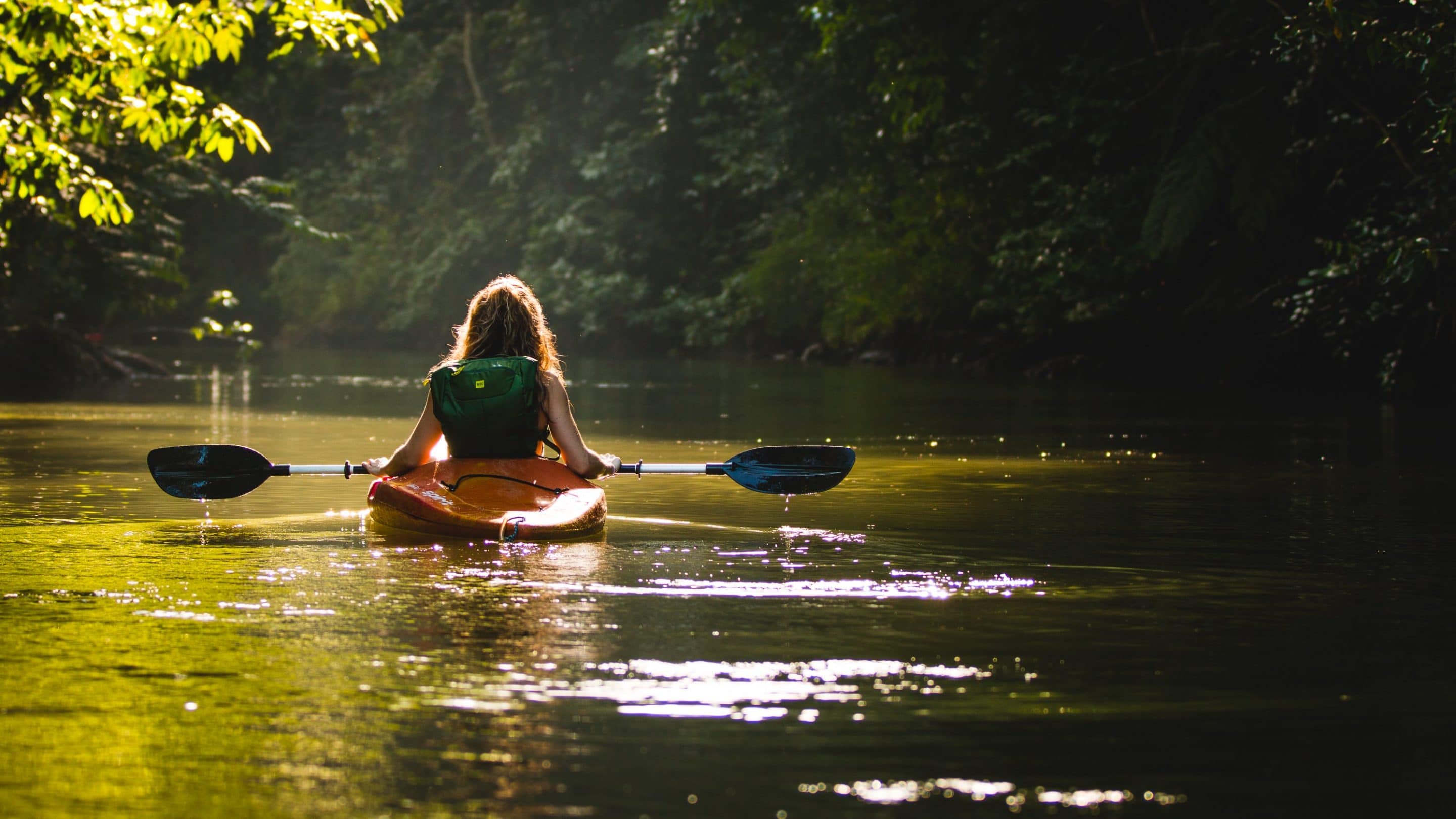 Woman kayaking down a relaxing river in Elizabeth City.